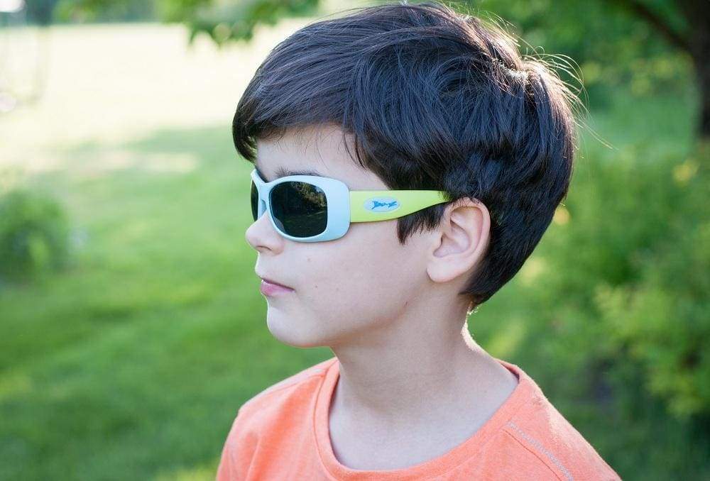school age child wears banz sunglasses while in a park